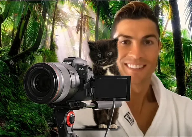 MOKI perched on a cinema camera in a jungle while a man takes a selfie in front of it